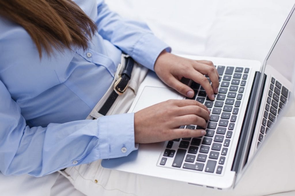 Close-up view of hands using laptop